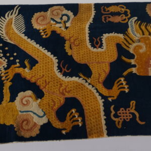 Navy blue rug featuring intricate gold and rust-colored mythological dragons and dense swirling cloud motifs.