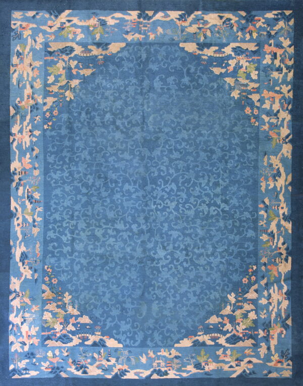 Blue rug featuring a tone-on-tone vine pattern center and an elaborate scenic landscape border in tan and pink.