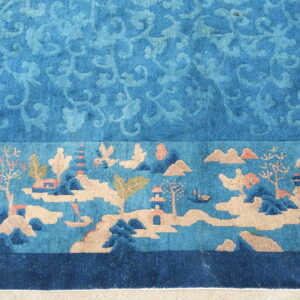 Teal and tan rug featuring a subtle scrolled field and a wide border depicting a detailed scenic landscape.