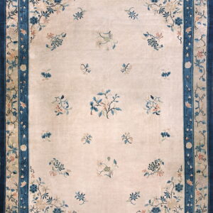 High pile rug featuring a cream field with scattered blue florals and a wide, layered dark blue border.