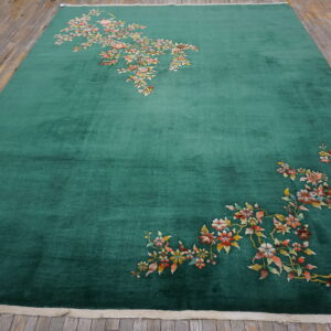 High-pile emerald green rug with scattered floral pattern on rustic plank wood floor.