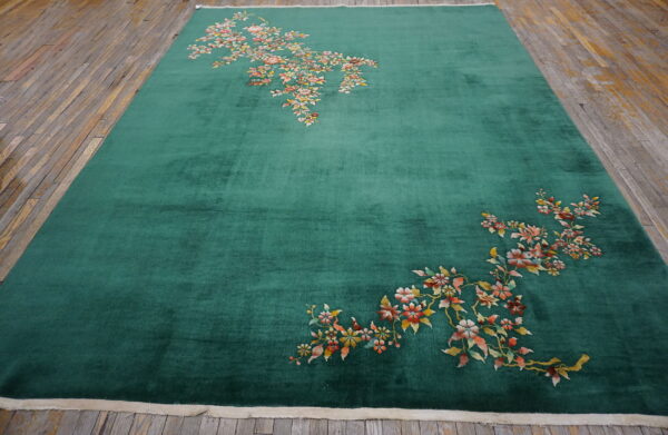 High-pile emerald green rug with scattered floral pattern on rustic plank wood floor.
