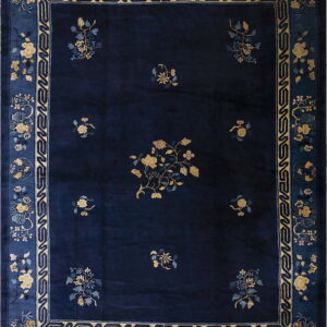 Rectangular, deep blue rug with yellow botanical motifs and a multi-layered medium blue border.