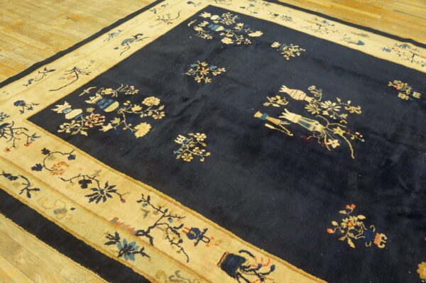 Navy high-pile rug featuring multicolored flower and vase designs within a thick cream border on wood plank floor.