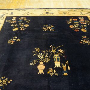 Deep blue rug featuring scattered yellow and multi-colored floral vase designs and a wide pale border.