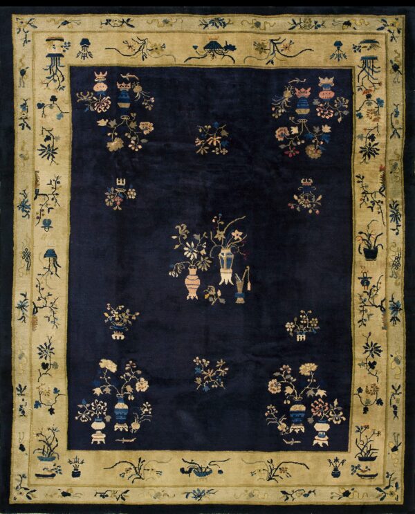 Navy blue rug featuring stylized floral vase motifs and a wide, detailed gold pictorial border.