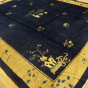Traditional blue and gold rug with scattered floral designs resting on distressed wood planks.