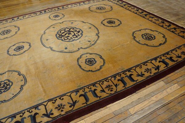 Yellow rug featuring blue medallion motifs and border designs on distressed hardwood flooring.