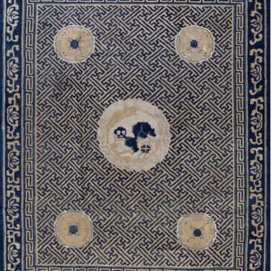 Geometric blue and tan rug with a fretwork field pattern and a decorative central animal medallion.