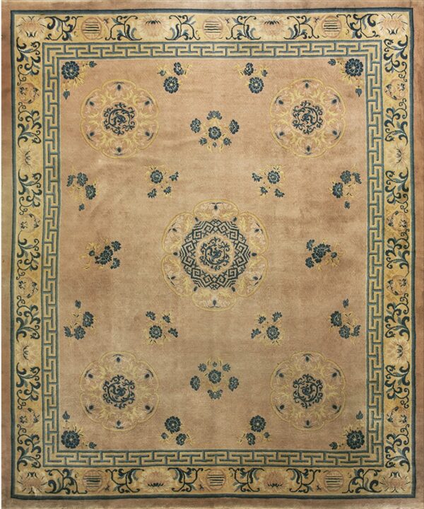 Muted pink rug featuring blue and yellow stylized floral medallions and a geometric border pattern.