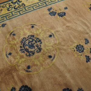 Plush pink rug showing a blue and yellow medallion pattern and a teal key border.