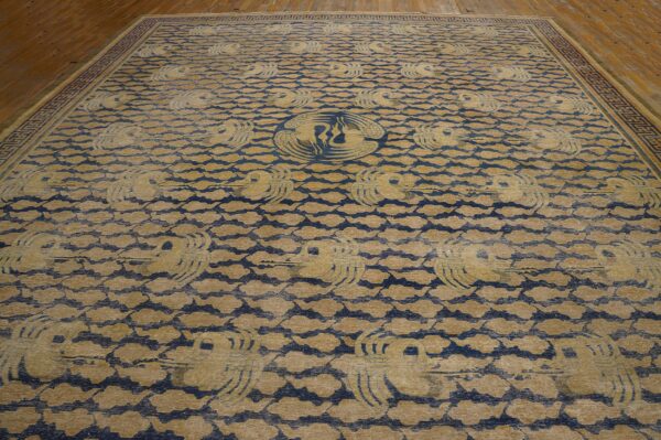 Tan and blue rug with stylized flying cranes and cloud pattern on wooden plank flooring.