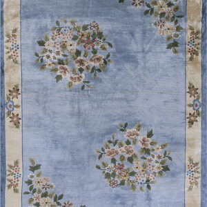 Blue floral area rug featuring large center bouquets and a rounded beige border with repeating flowers.