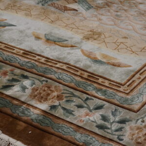 Textured rug detail with tan, beige, and teal borders featuring florals and cloud motifs.