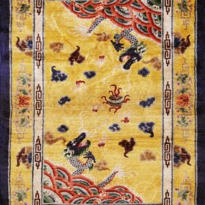 Golden yellow rectangular rug displaying dragons, clouds, and floral borders set against navy blue.