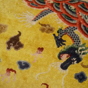Textured yellow rug with detailed blue and red dragon motif and brown, dark blue cloud designs.