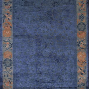 Deep blue high-pile rug with subtle scrolling patterns and a wide border of rust and pink floral medallions.