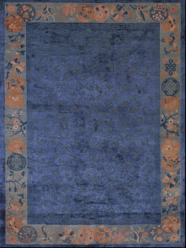 Deep blue high-pile rug with subtle scrolling patterns and a wide border of rust and pink floral medallions.