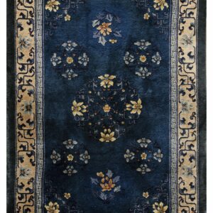 Rectangular blue rug featuring intricate gold and gray floral designs inside a thick beige border.