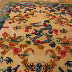Plush yellow rug with detailed blue and gold dragon patterns and colorful borders rests on wide plank wood floors.