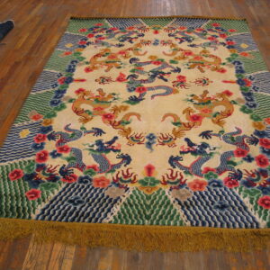 Large cream rug featuring elaborate yellow and blue dragon patterns, colorful borders, and yellow fringe on wood planks.