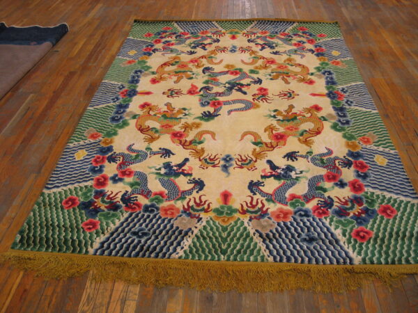 Large cream rug featuring elaborate yellow and blue dragon patterns, colorful borders, and yellow fringe on wood planks.