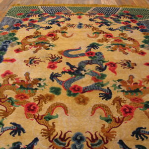 Yellow-gold rug with sculpted, colorful dragon and cloud motifs rests on light wood plank flooring.