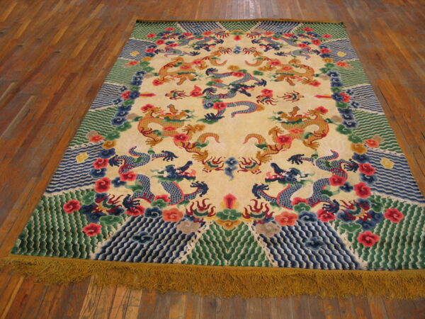 Colorful rug featuring dragons on a pale yellow field, bordered by green waves, with long visible golden fringe.