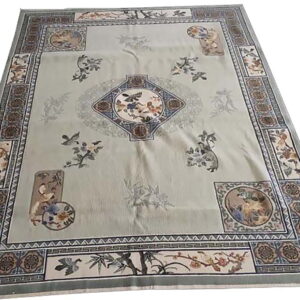 Muted green area rug with intricate Asian motifs, scenic vignettes, a center diamond, and complex borders.