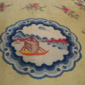 Pale yellow plush rug detailed with a blue landscape medallion and pink floral motifs.