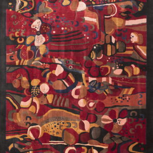 Sculpted abstract area rug in red, gold, black, and brown with large organic shapes.