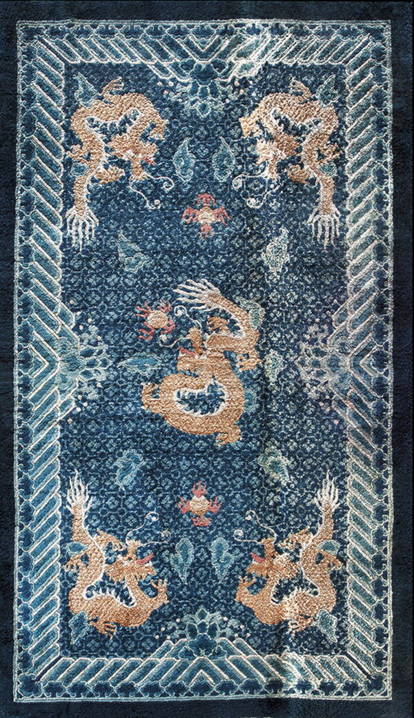Navy blue rug with a textured tan dragon pattern and a blue and white interlocking geometric border.