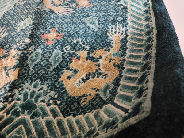 Highly textured teal rug with detailed golden dragon motifs, coral accents, and a stepped border design.