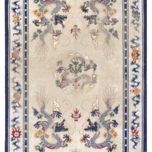 Cream rug featuring multiple blue dragon motifs and elaborate borders with stripes of red, yellow, and blue.