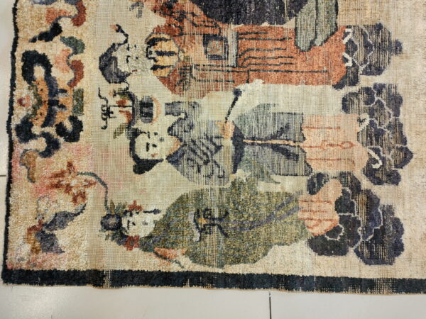 A low-pile rug shows a complex pattern in beige, rust, olive green, and dark blue colors.