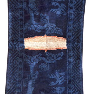 A dark navy runner rug with lighter blue animal and tree motifs and a light beige central band.