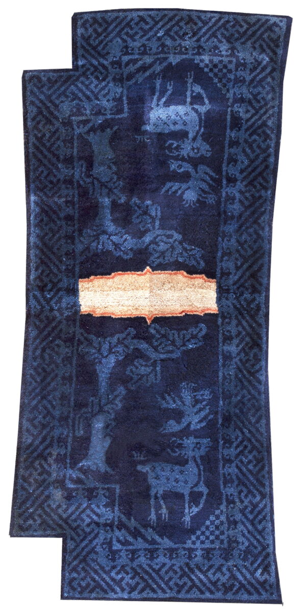 A dark navy runner rug with lighter blue animal and tree motifs and a light beige central band.
