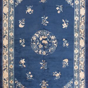 A navy blue rug featuring a large circular floral medallion in cream and dark blue colors.