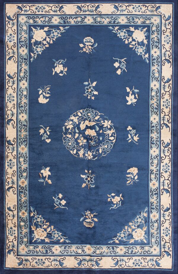 A navy blue rug featuring a large circular floral medallion in cream and dark blue colors.