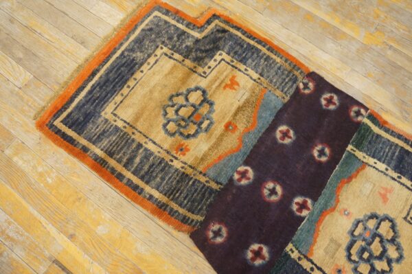 Two patterned rugs, featuring navy, tan, orange, and deep purple colors, are angled across light wood flooring.