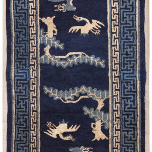 Dark blue runner rug with beige and teal stylized animal figures and complex geometric borders.