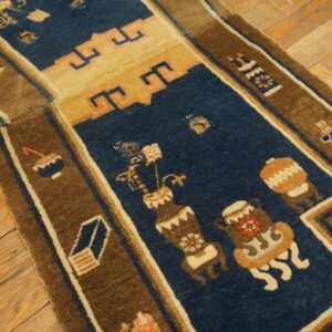 Close-up of a damaged blue and brown patterned rug with holes exposing the wooden floor underneath.