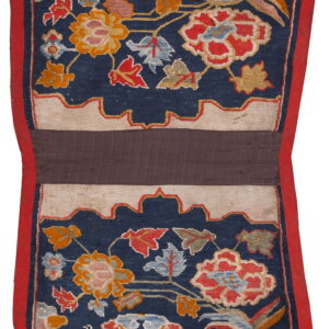 Vibrantly patterned blue rug with multicolored florals, framed by a red border and central brown stripe.