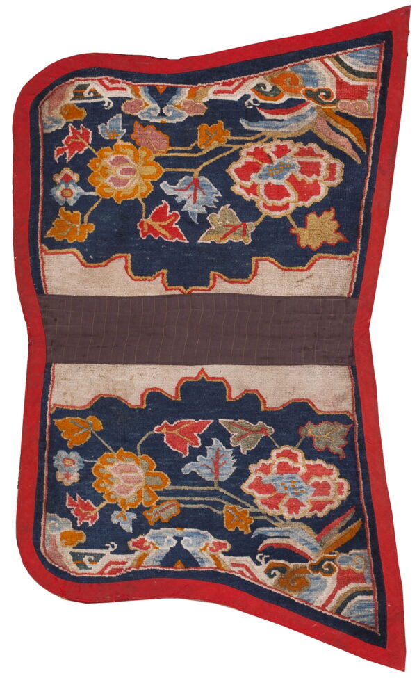 Vibrantly patterned blue rug with multicolored florals, framed by a red border and central brown stripe.