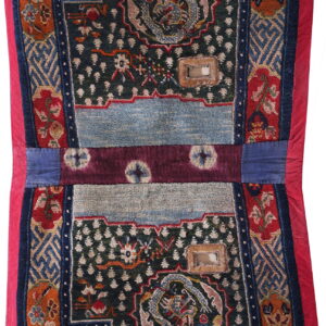Stepped, low-pile rug with blue, red, and green geometric and dragon motifs, edged in vibrant red fabric.
