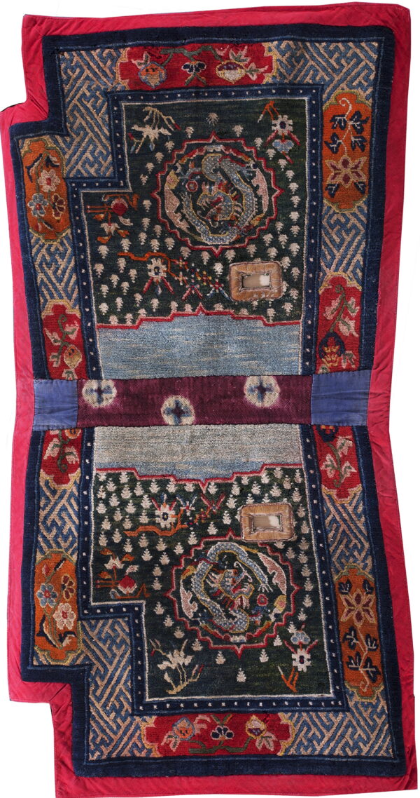 Stepped, low-pile rug with blue, red, and green geometric and dragon motifs, edged in vibrant red fabric.