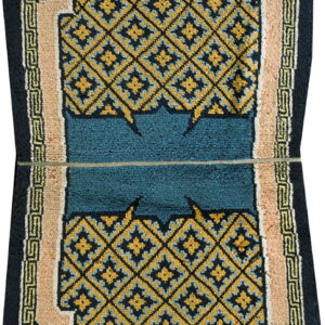 Octagonal rug with navy and gold geometric diamond field and a central teal panel, bordered by beige.