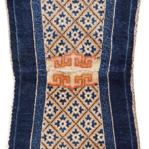 Oblong blue rug with rounded ends, featuring a tan diamond pattern and reddish-orange central detail.