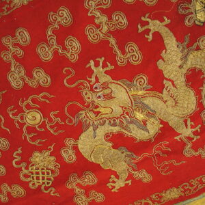 Low-pile red rug featuring a large gold embroidered dragon and surrounding stylized cloud motifs.
