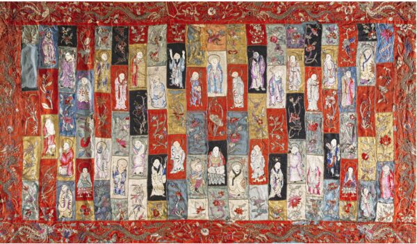 Intricate embroidered textile with columns of colorful patch blocks depicting figures and scrolling floral vines on a red ground.